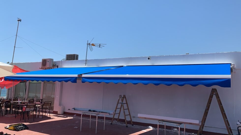 Instalación de un toldo azul sobre la terraza de un local