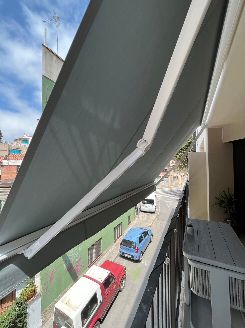 Toldo de brazos articulados extendido sobre una terraza en Badalona