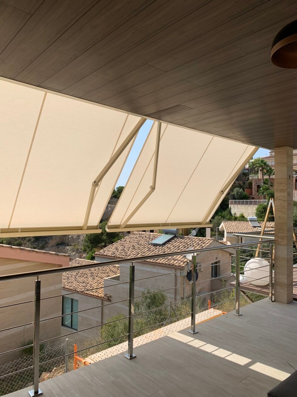 Toldo cofre color crema extendido sobre la terraza de una vivienda