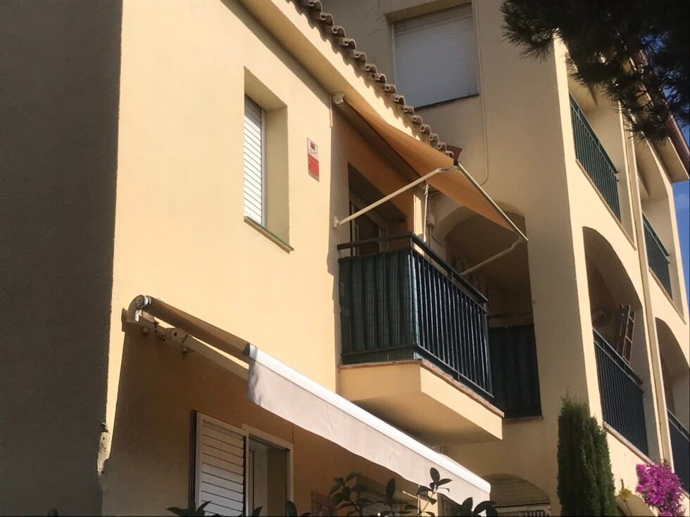 Toldo punto recto instalado sobre la ventana de una fachada