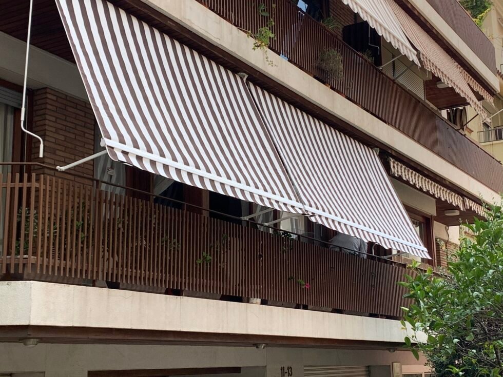 Toldo telón abierto con brazos sobre el balcón de una vivienda