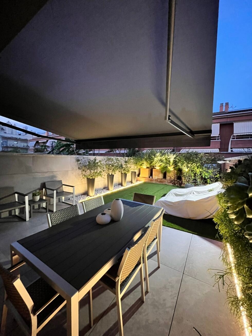 Toldo de brazos extendido sobre la terraza de un ático al anochecer